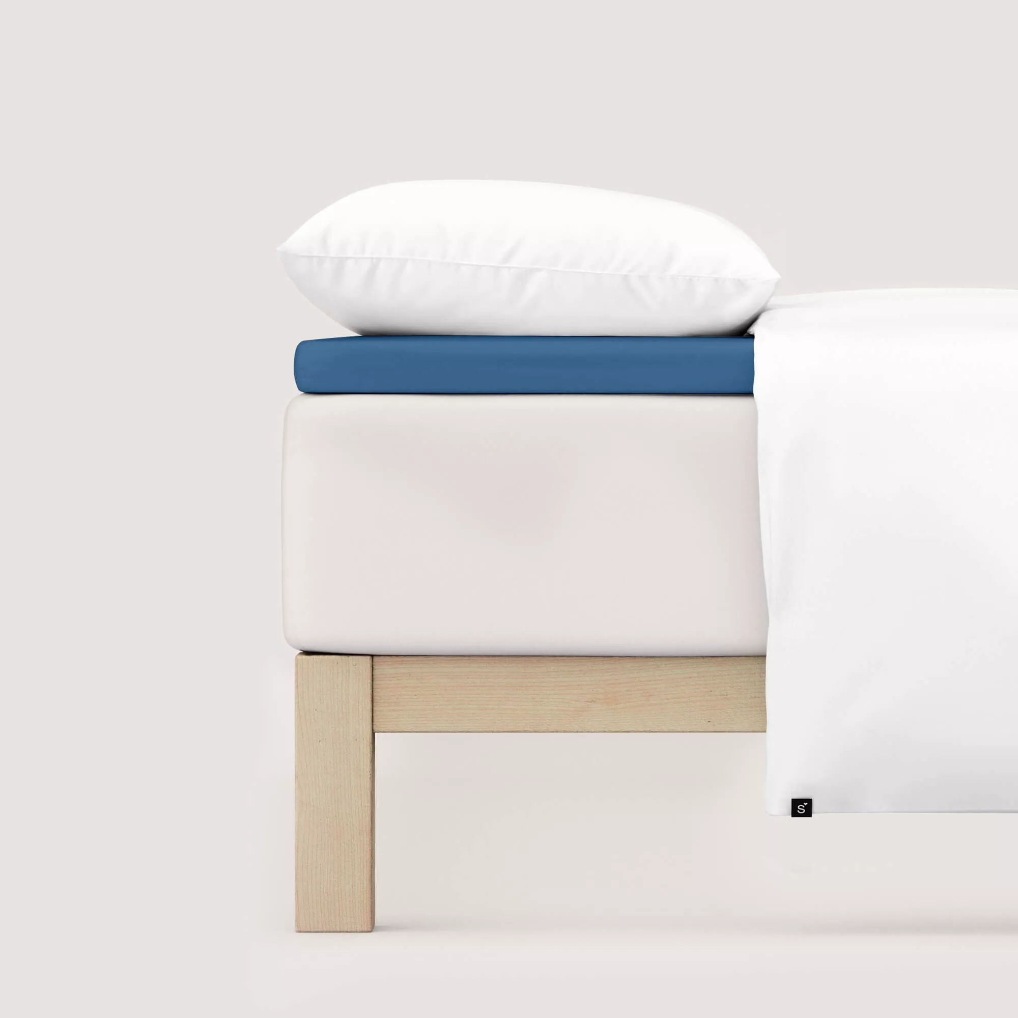 Spannbettlaken Pure Topper von Schlafgut in Farbe blue mid aus 95% Bio-Baumwolle und 5% Elasthan auf Bett seitlich