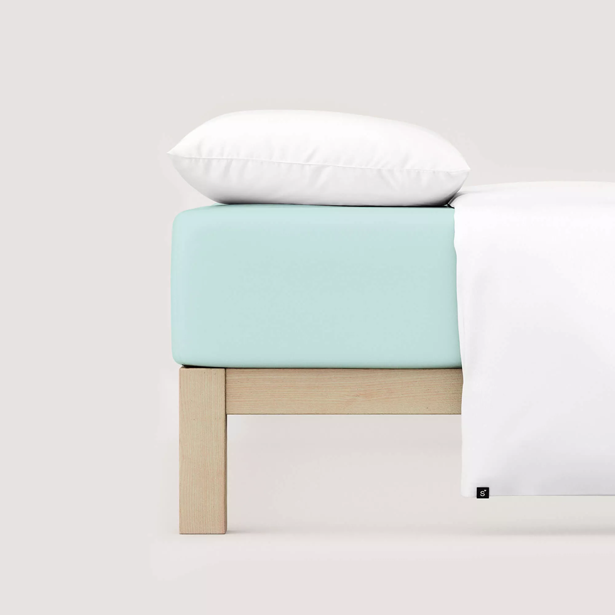 Spannbettlaken Casual von Schlafgut in Farbe petrol light aus 100% Bio-Baumwolle auf Bett mit Kissen und Decke