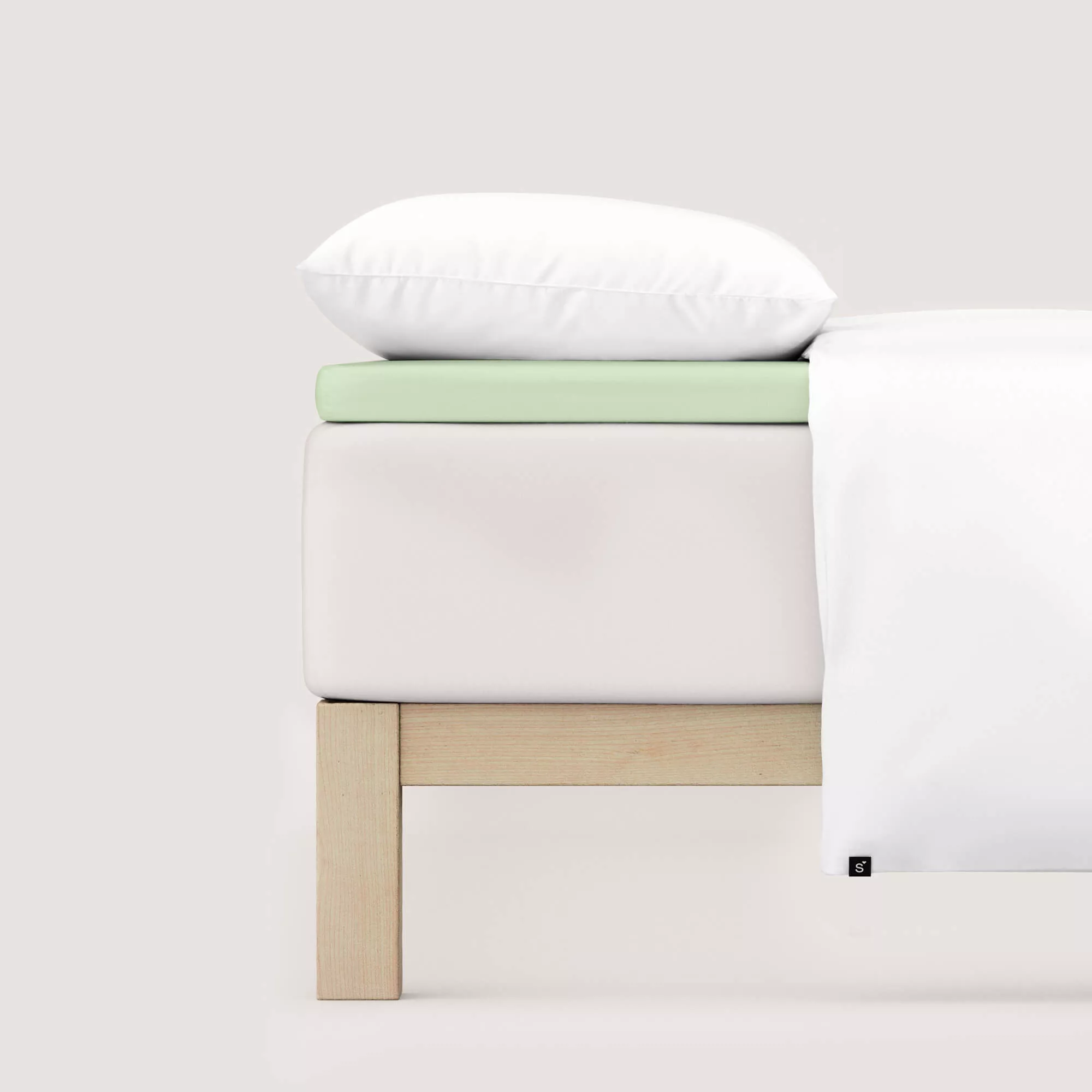 Spannbettlaken Pure Topper von Schlafgut in Farbe green light aus 95% Bio-Baumwolle und 5% Elasthan auf Bett seitlich