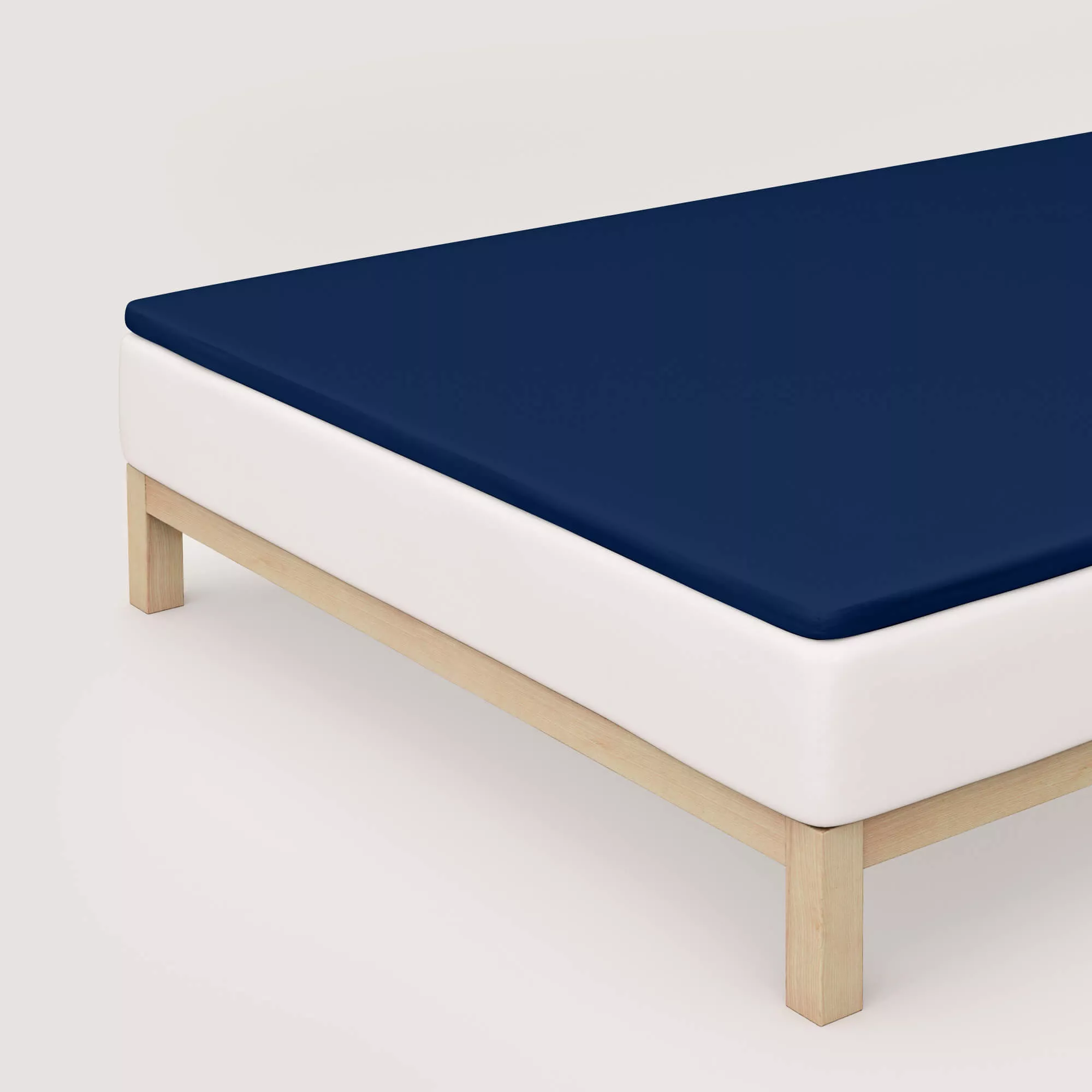 Spannbettlaken Pure Topper von Schlafgut in Farbe blue deep aus 95% Bio-Baumwolle und 5% Elasthan auf Bett in Vogelperspektive