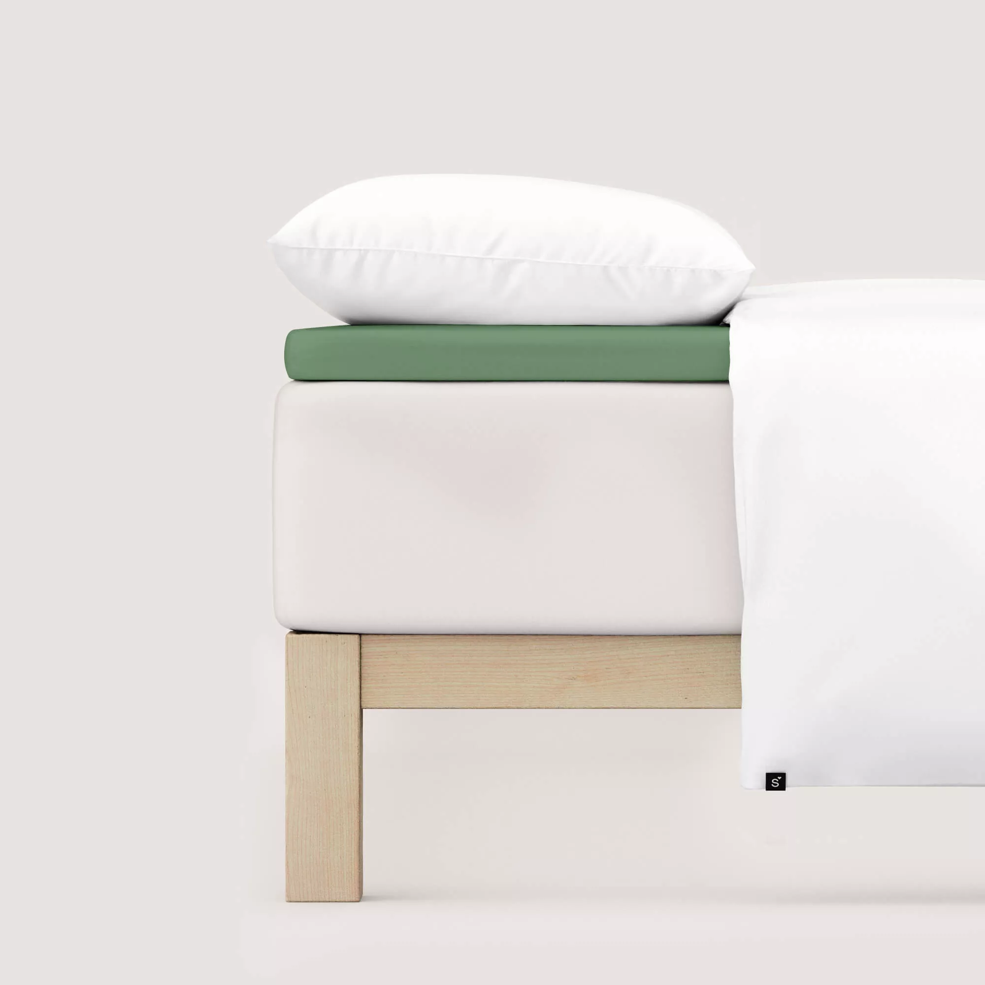 Spannbettlaken Pure Topper von Schlafgut in Farbe green mid aus 95% Bio-Baumwolle und 5% Elasthan auf Bett seitlich