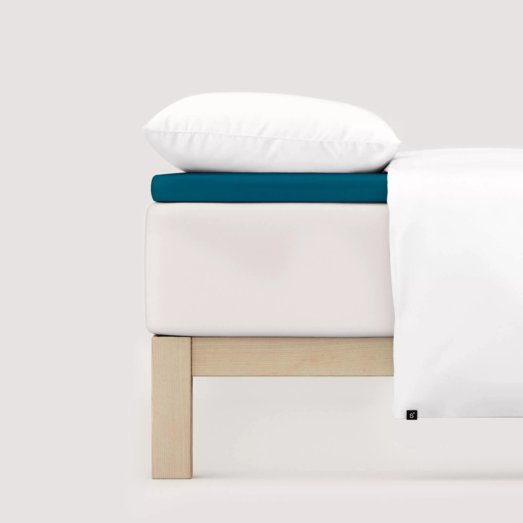Spannbettlaken Pure Topper von Schlafgut in Farbe petrol deep aus 95% Bio-Baumwolle und 5% Elasthan auf Bett seitlich