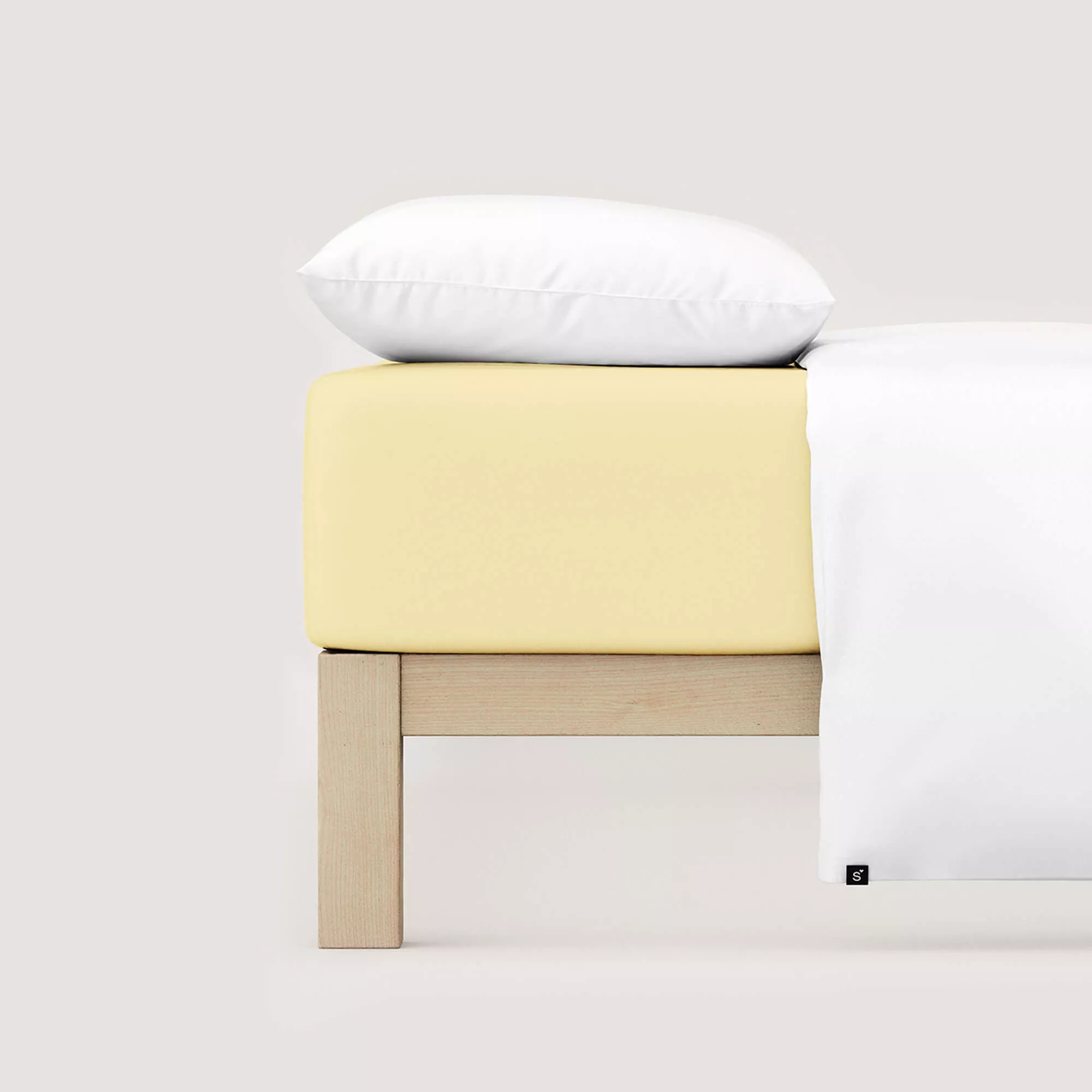 Spannbettlaken Casual von Schlafgut in Farbe yellow mid aus 100% Bio-Baumwolle auf Bett mit Kissen und Decke