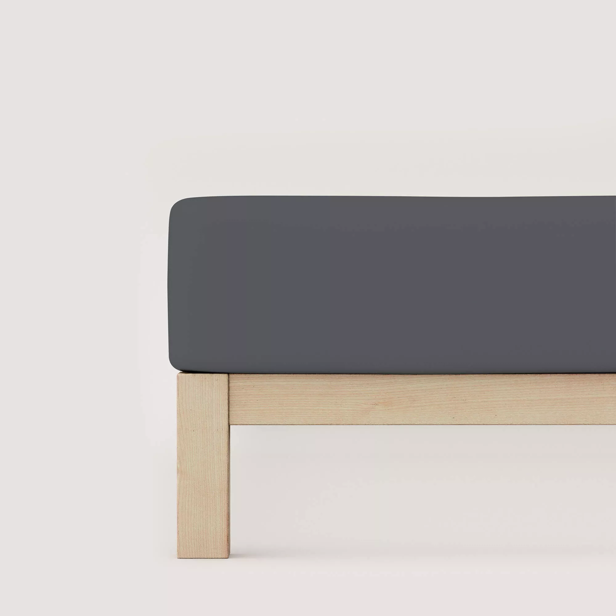 Spannbettlaken Pure von Schlafgut in Farbe grey deep aus 95% Bio-Baumwolle und 5% Elasthan auf Bett seitlich