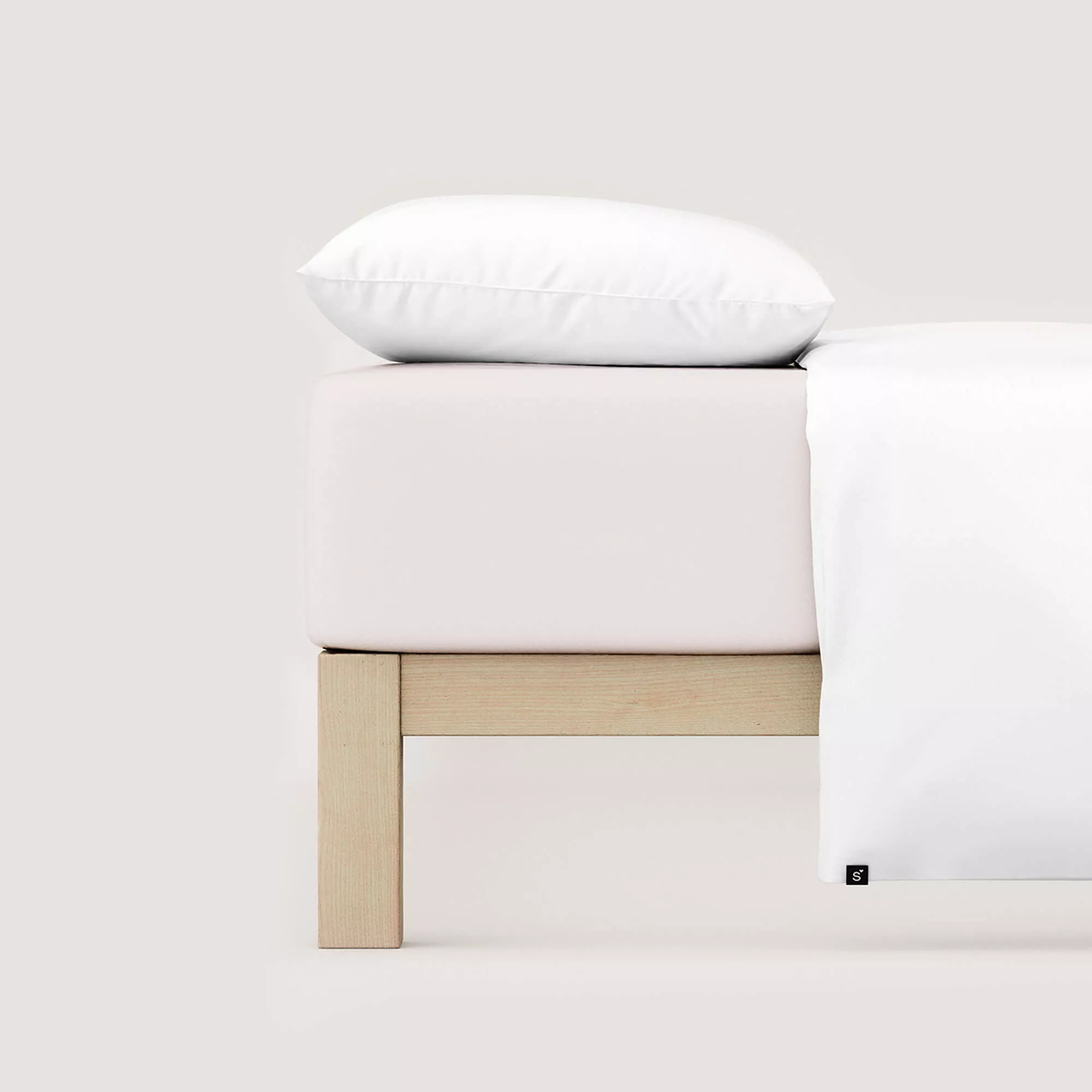 Spannbettlaken Pure von Schlafgut in Farbe sand light aus 95% Bio-Baumwolle und 5% Elasthan auf Bett mit Kissen und Decke