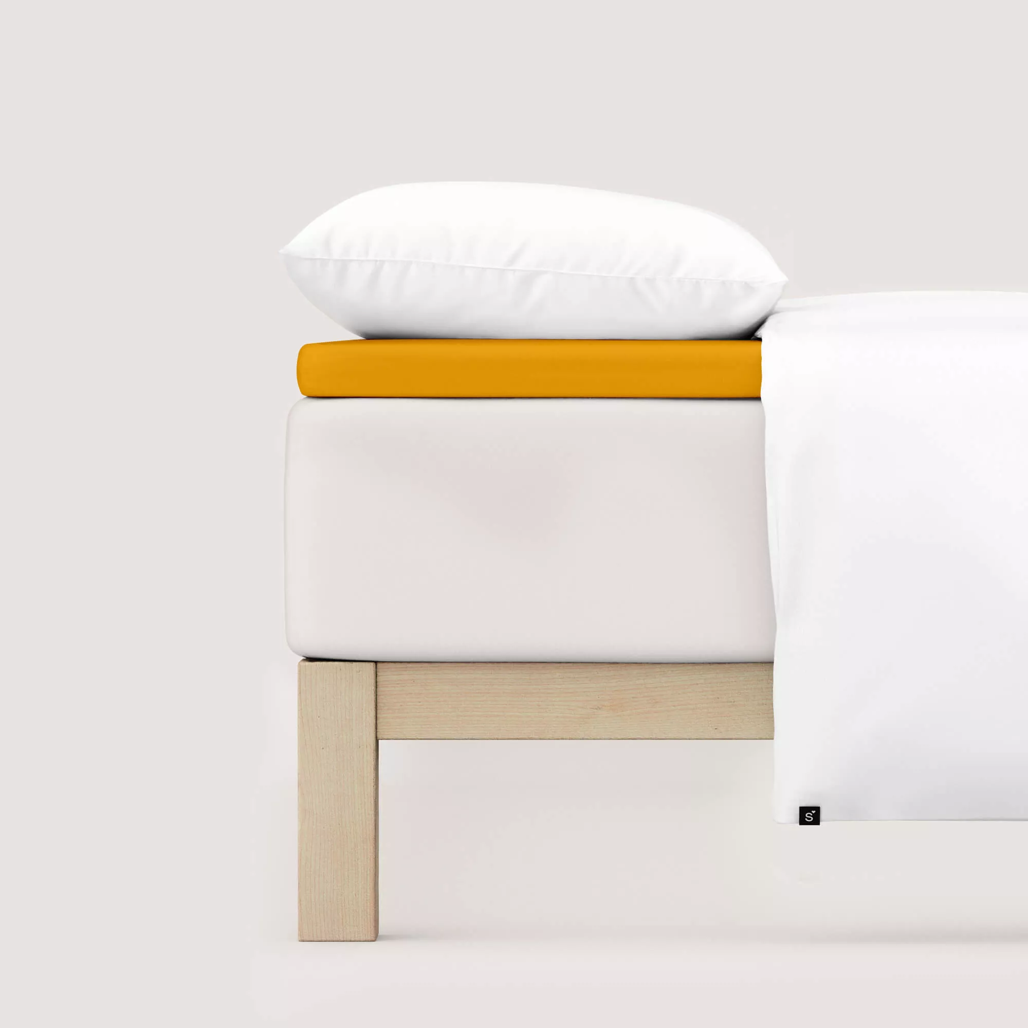 Spannbettlaken Pure Topper von Schlafgut in Farbe yellow deep aus 95% Bio-Baumwolle und 5% Elasthan auf Bett seitlich