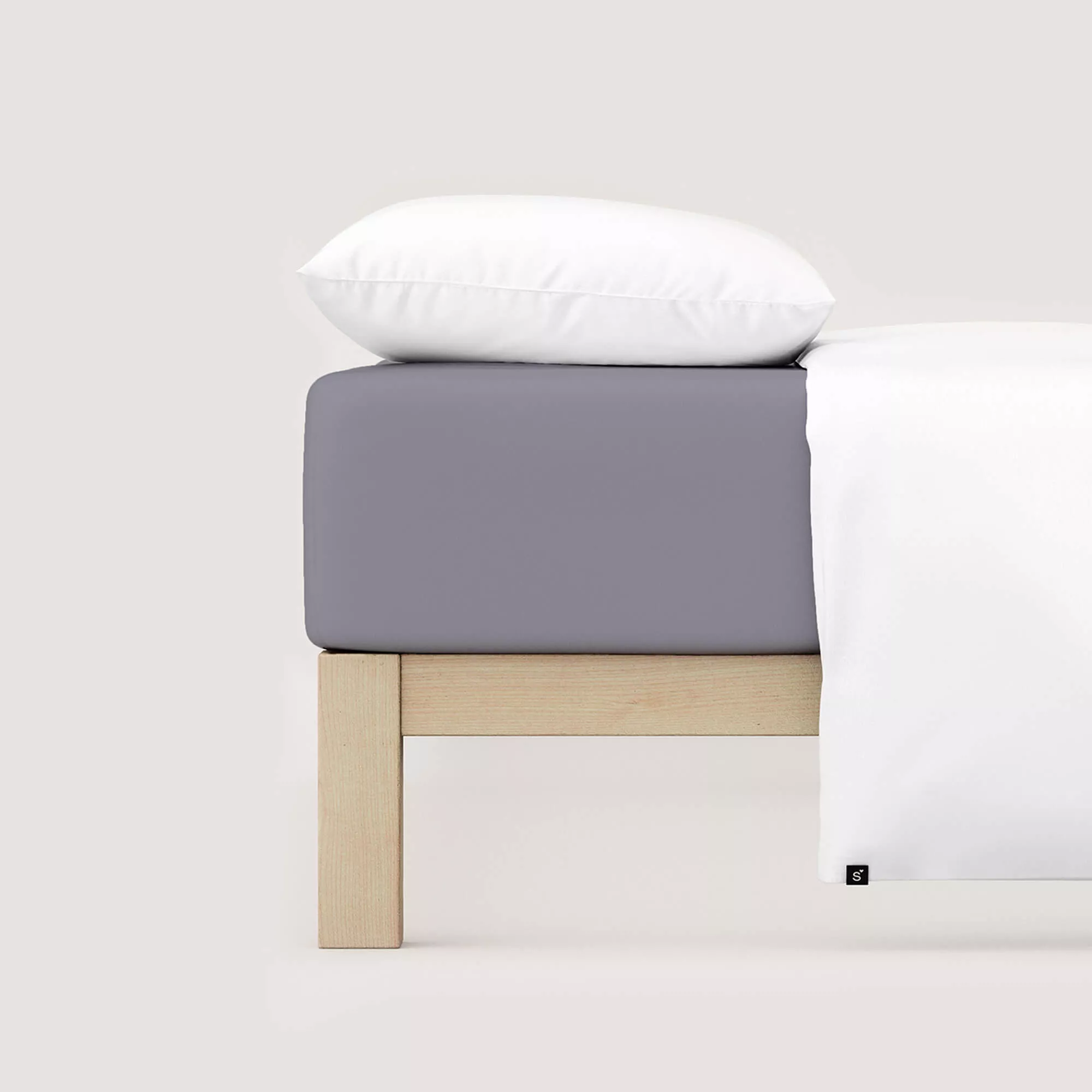 Spannbettlaken Pure von Schlafgut in Farbe grey mid aus 95% Bio-Baumwolle und 5% Elasthan auf Bett mit Kissen und Decke