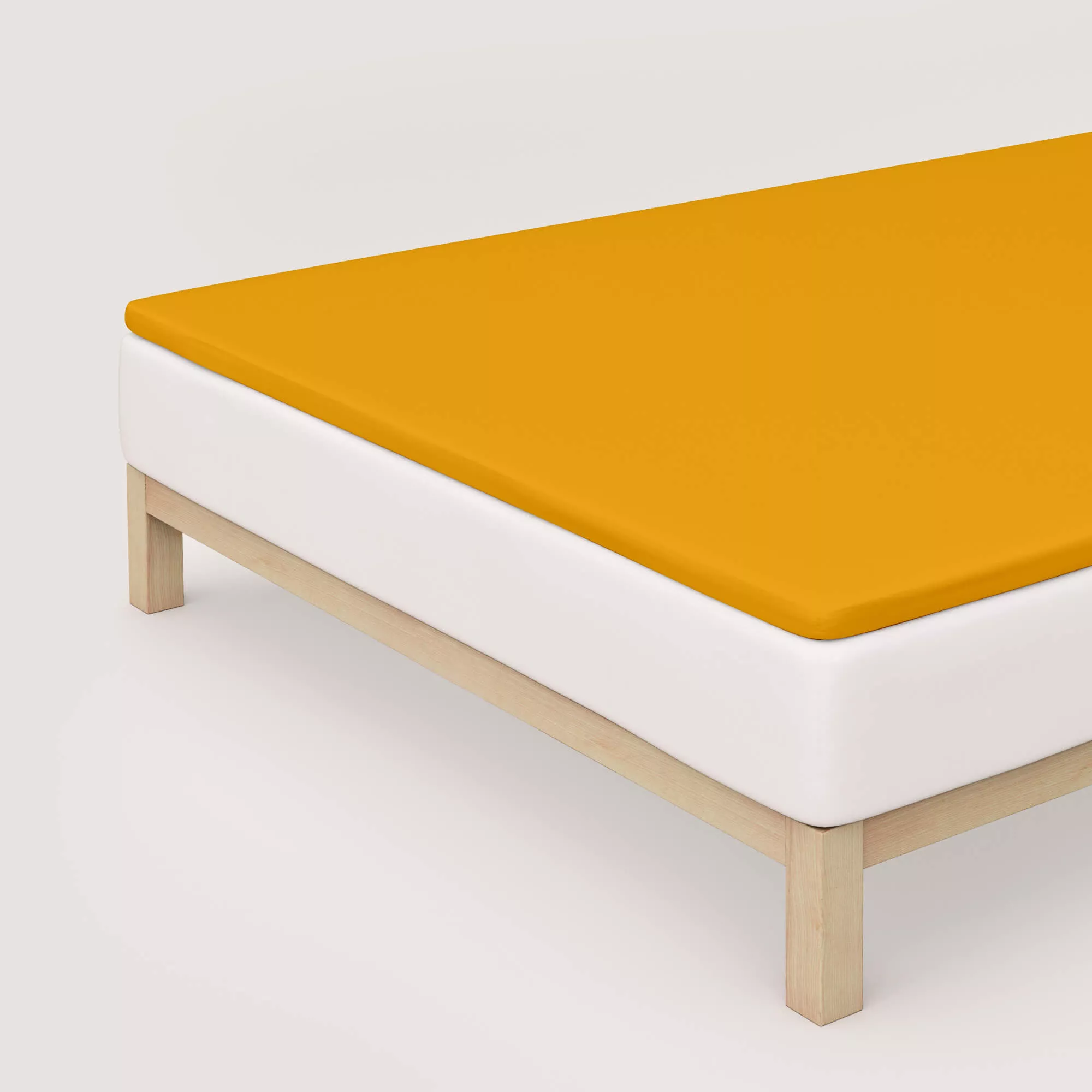 Spannbettlaken Pure Topper von Schlafgut in Farbe yellow deep aus 95% Bio-Baumwolle und 5% Elasthan auf Bett in Vogelperspektive