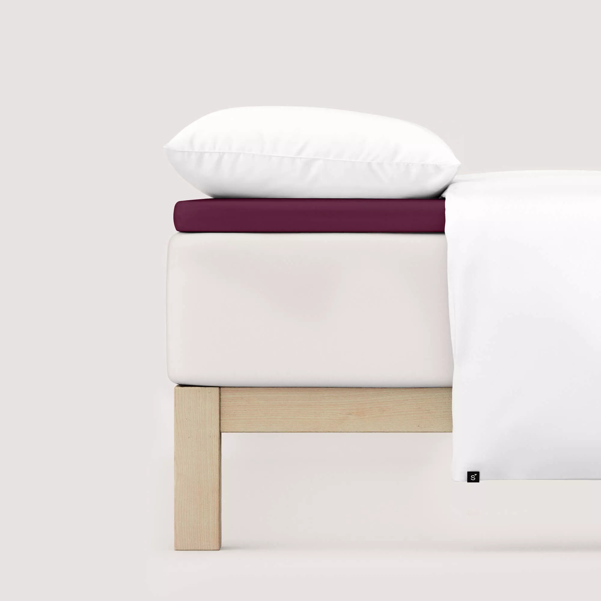 Spannbettlaken Pure Topper von Schlafgut in Farbe purple deep aus 95% Bio-Baumwolle und 5% Elasthan auf Bett seitlich