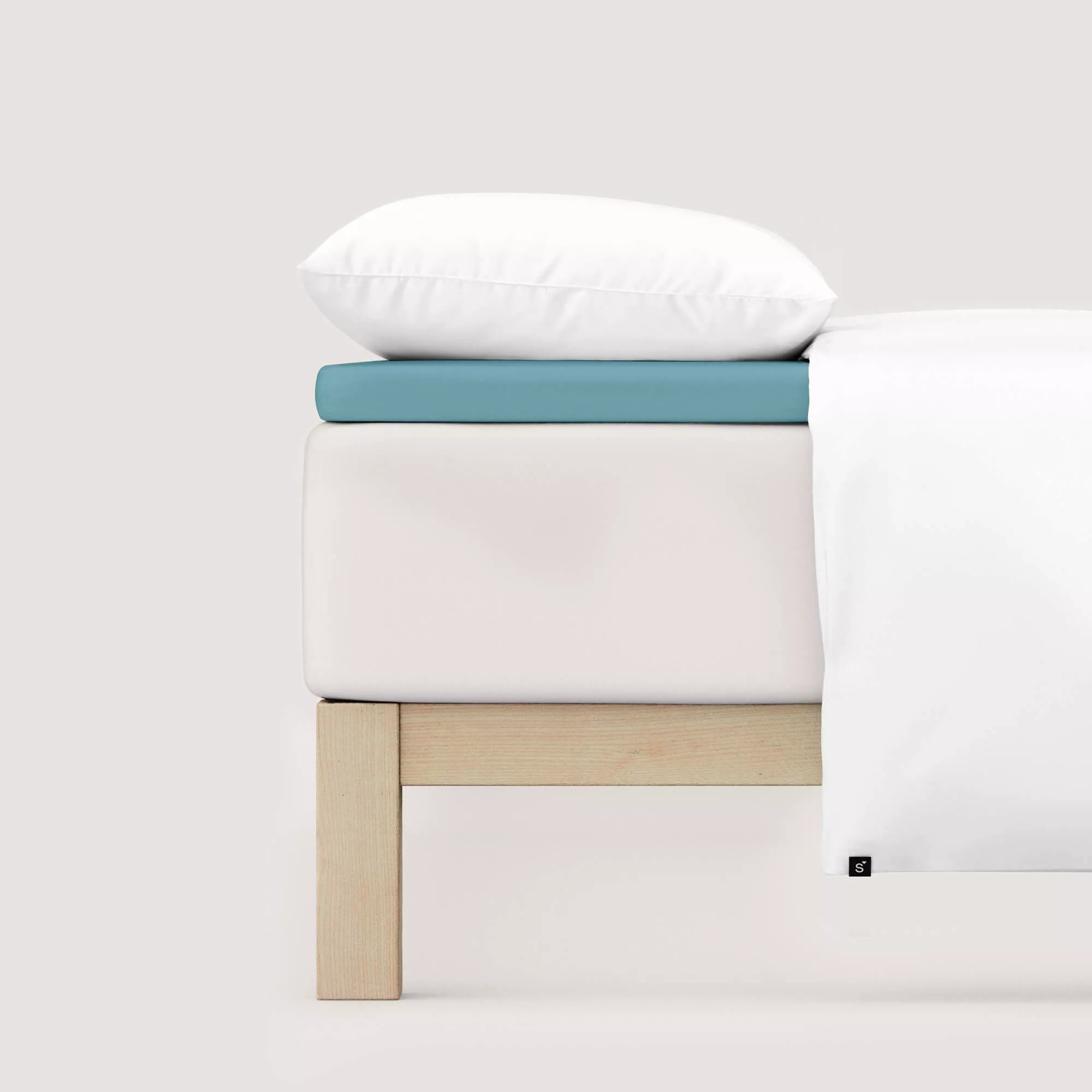 Spannbettlaken Pure Topper von Schlafgut in Farbe petrol mid aus 95% Bio-Baumwolle und 5% Elasthan auf Bett seitlich
