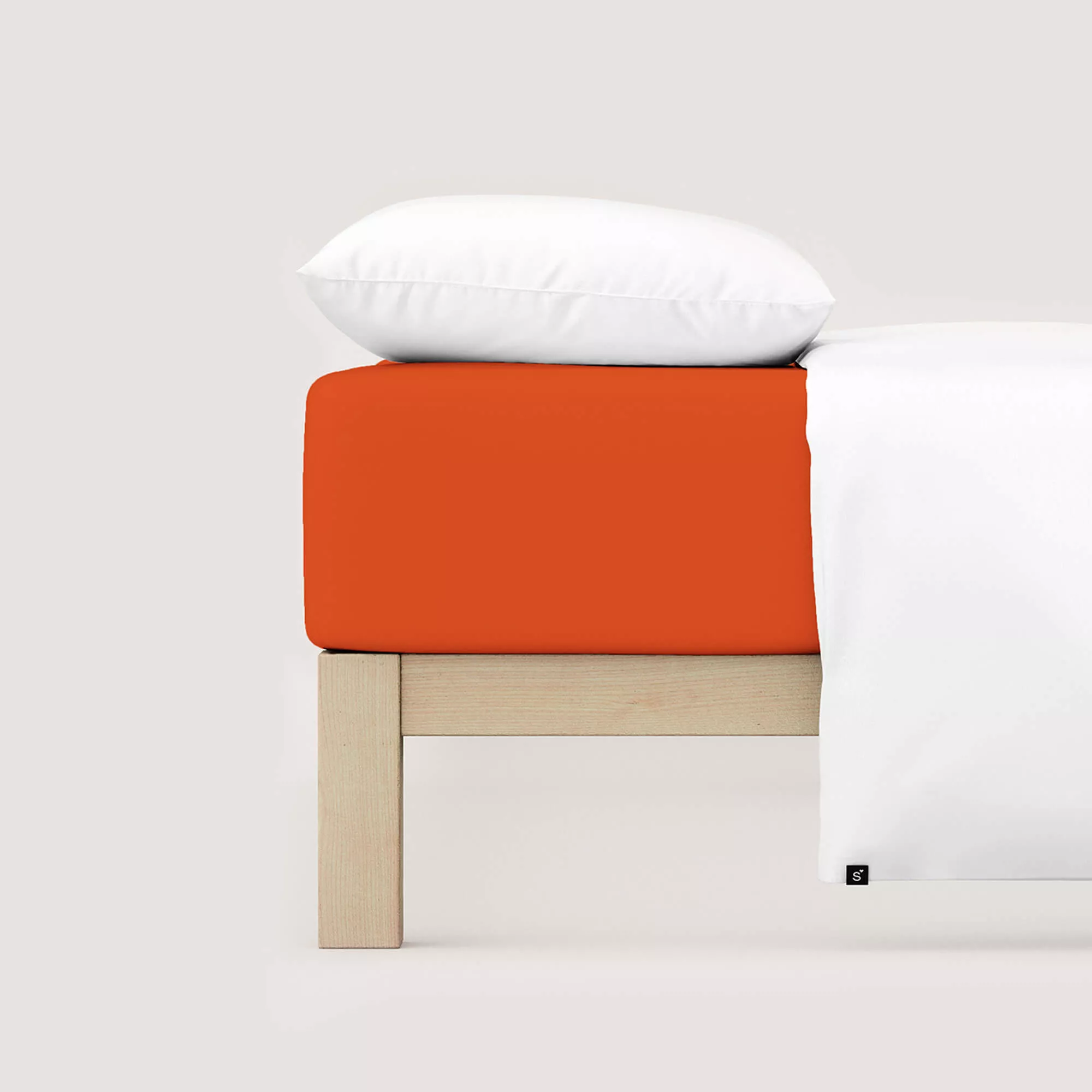 Spannbettlaken Casual von Schlafgut in Farbe red mid aus 100% Bio-Baumwolle auf Bett mit Kissen und Decke