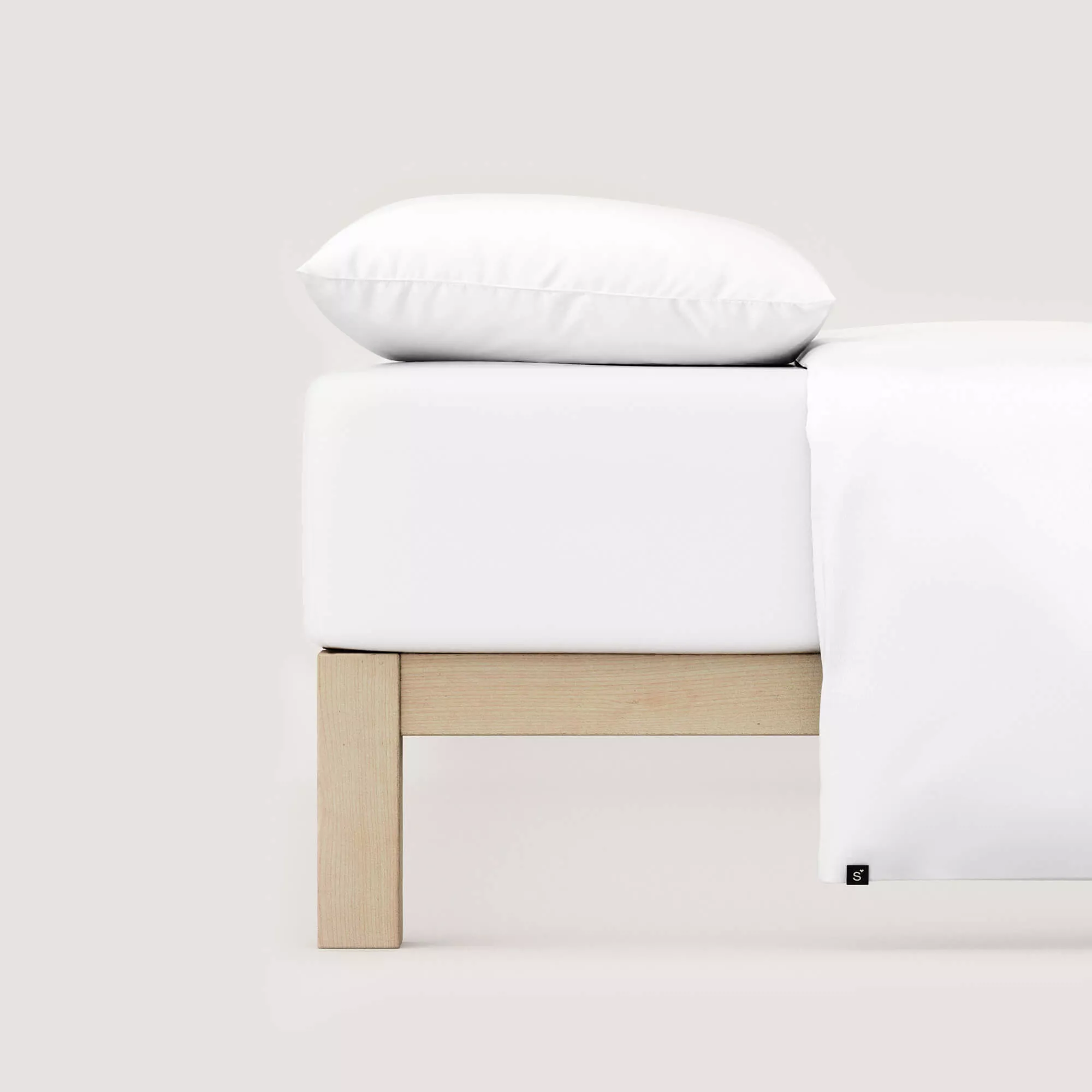 Spannbettlaken Pure von Schlafgut in Farbe full-white aus 95% Bio-Baumwolle und 5% Elasthan auf Bett mit Kissen und Decke