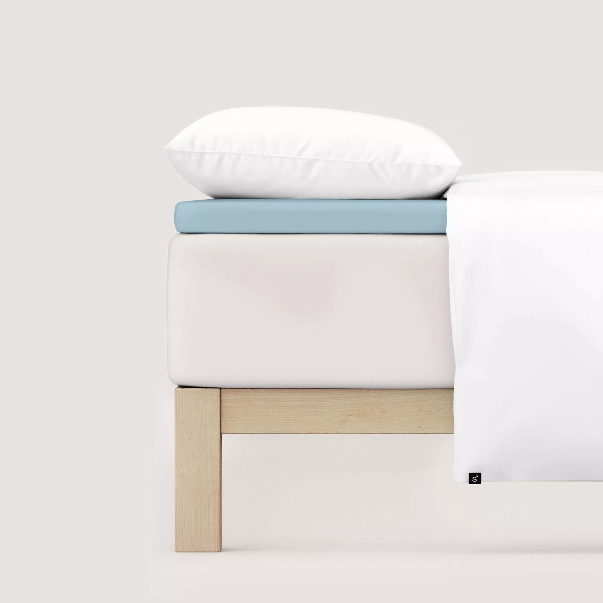 Spannbettlaken Pure Topper von Schlafgut in Farbe blue light aus 95% Bio-Baumwolle und 5% Elasthan auf Bett seitlich