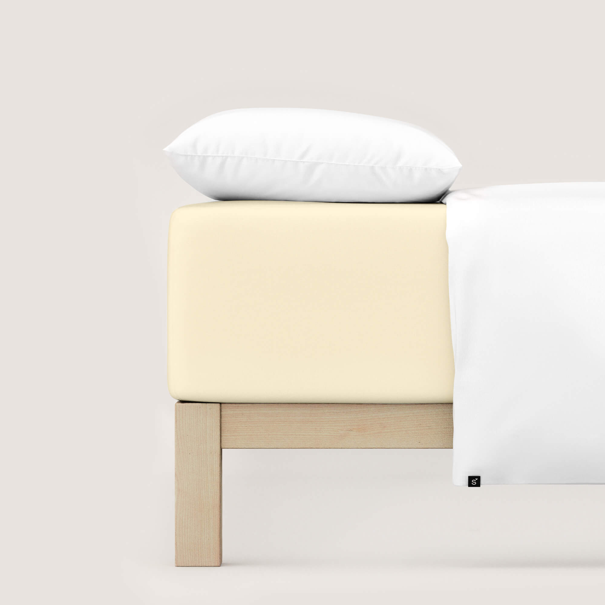 Spannbettlaken Pure Boxspring von Schlafgut in Farbe yellow light aus 95% Bio-Baumwolle und 5% Elasthan auf Bett mit Kissen und Decke 