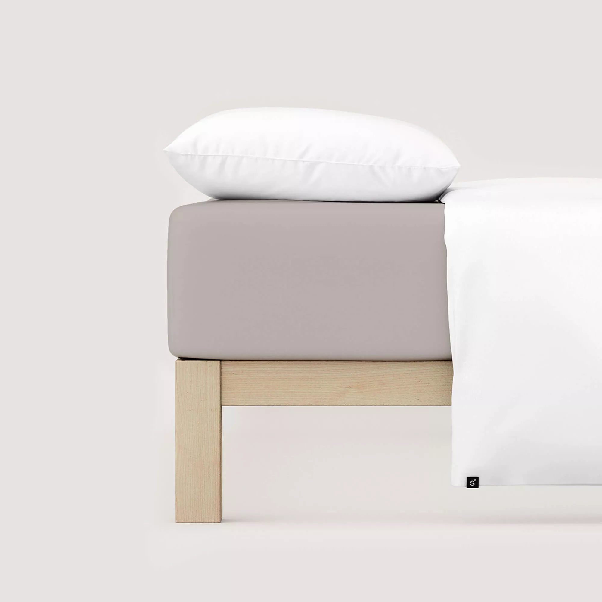 Spannbettlaken Pure von Schlafgut in Farbe sand mid aus 95% Bio-Baumwolle und 5% Elasthan auf Bett mit Kissen und Decke