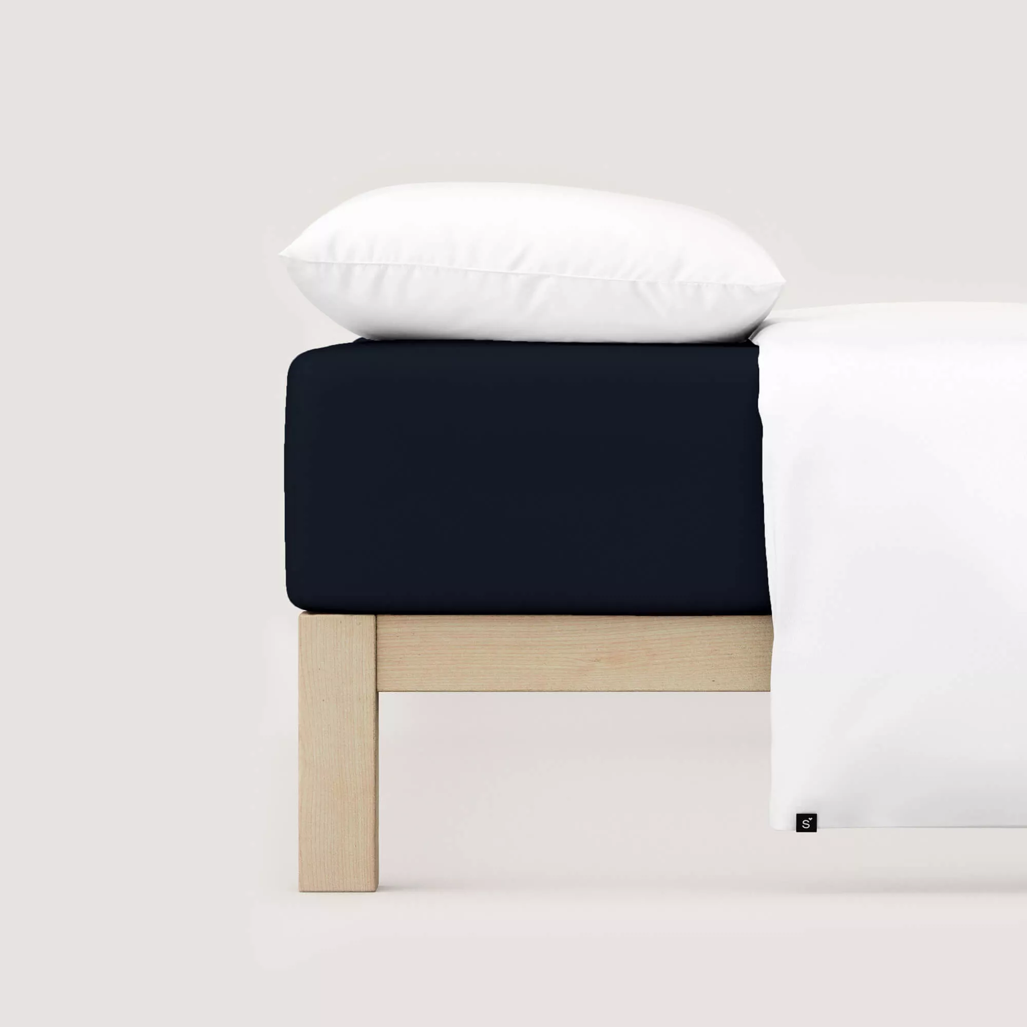 Spannbettlaken Casual von Schlafgut in Farbe off-black aus 100% Bio-Baumwolle auf Bett mit Kissen und Decke